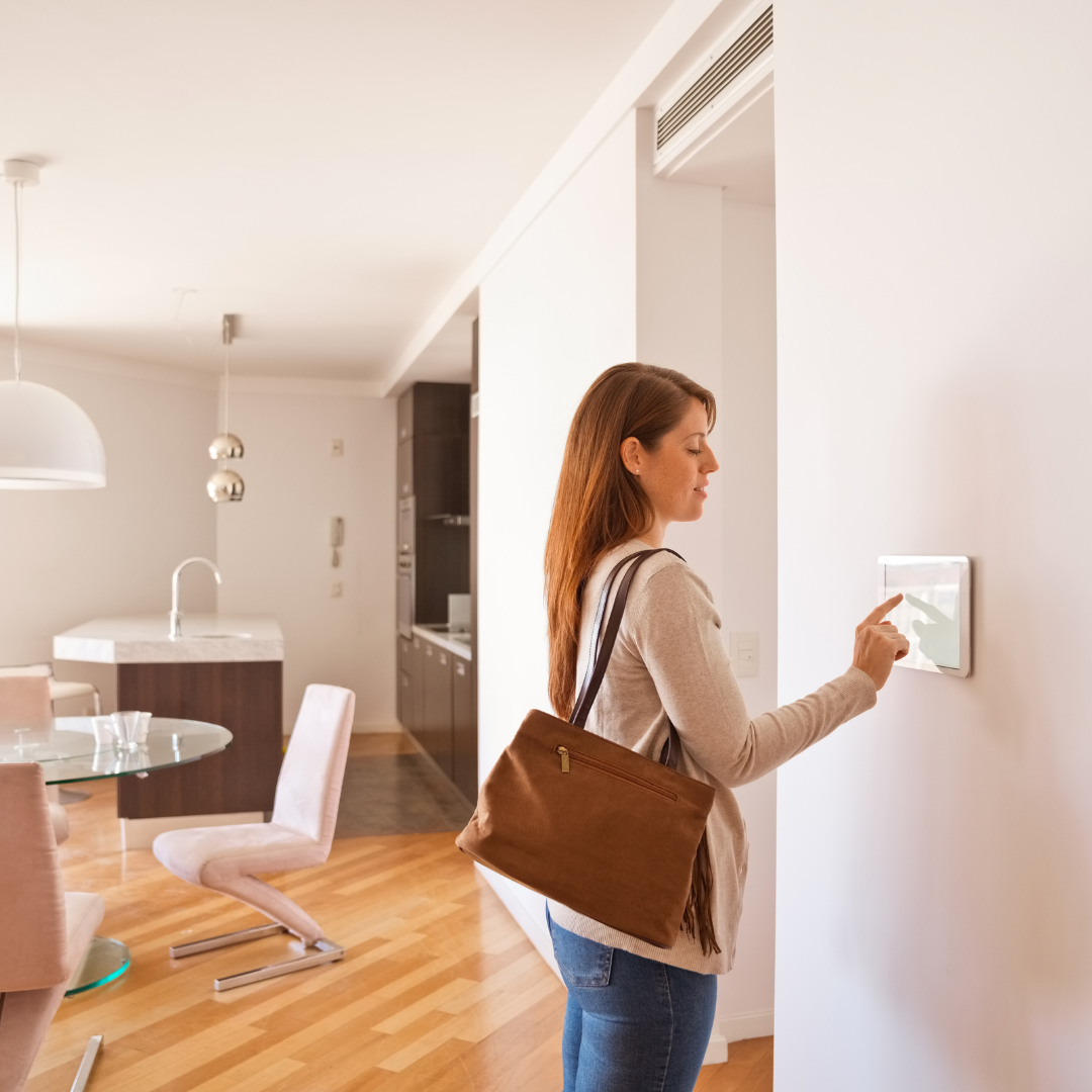 woman setting an alarm inside a home