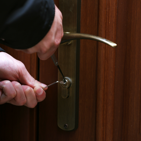 Someone breaking into a lock on a door
