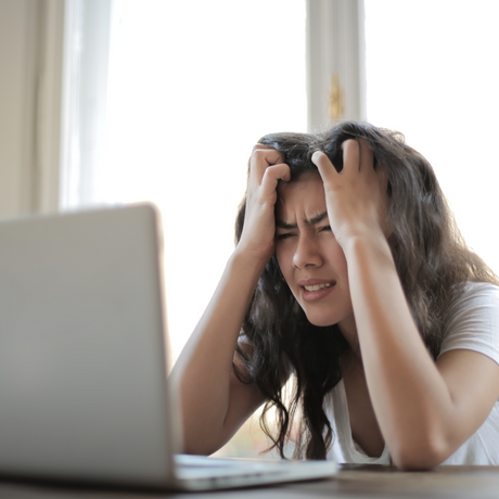 A woman using a laptop looking frustrated