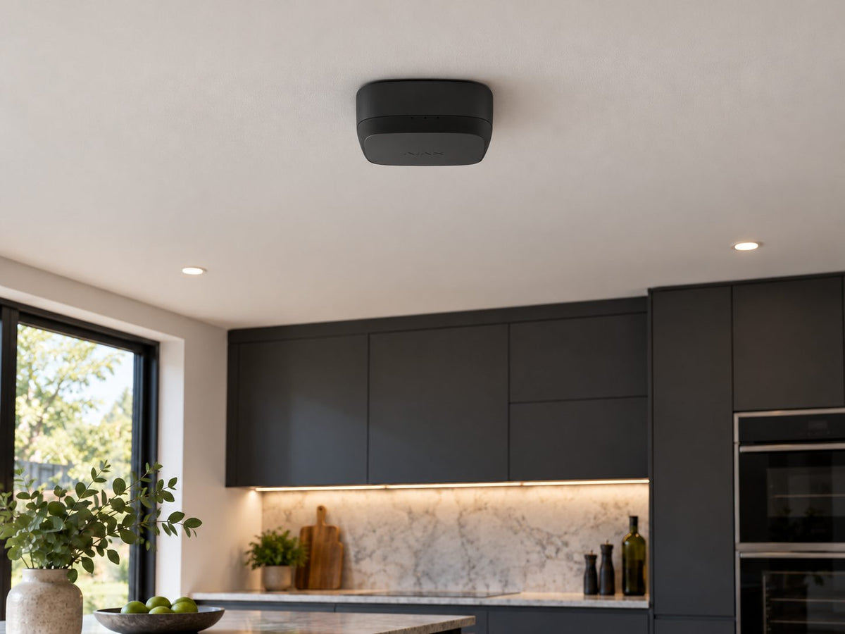 Ajax FireProtect 2 AC Heat/CO in a family kitchen with dark cabinets.