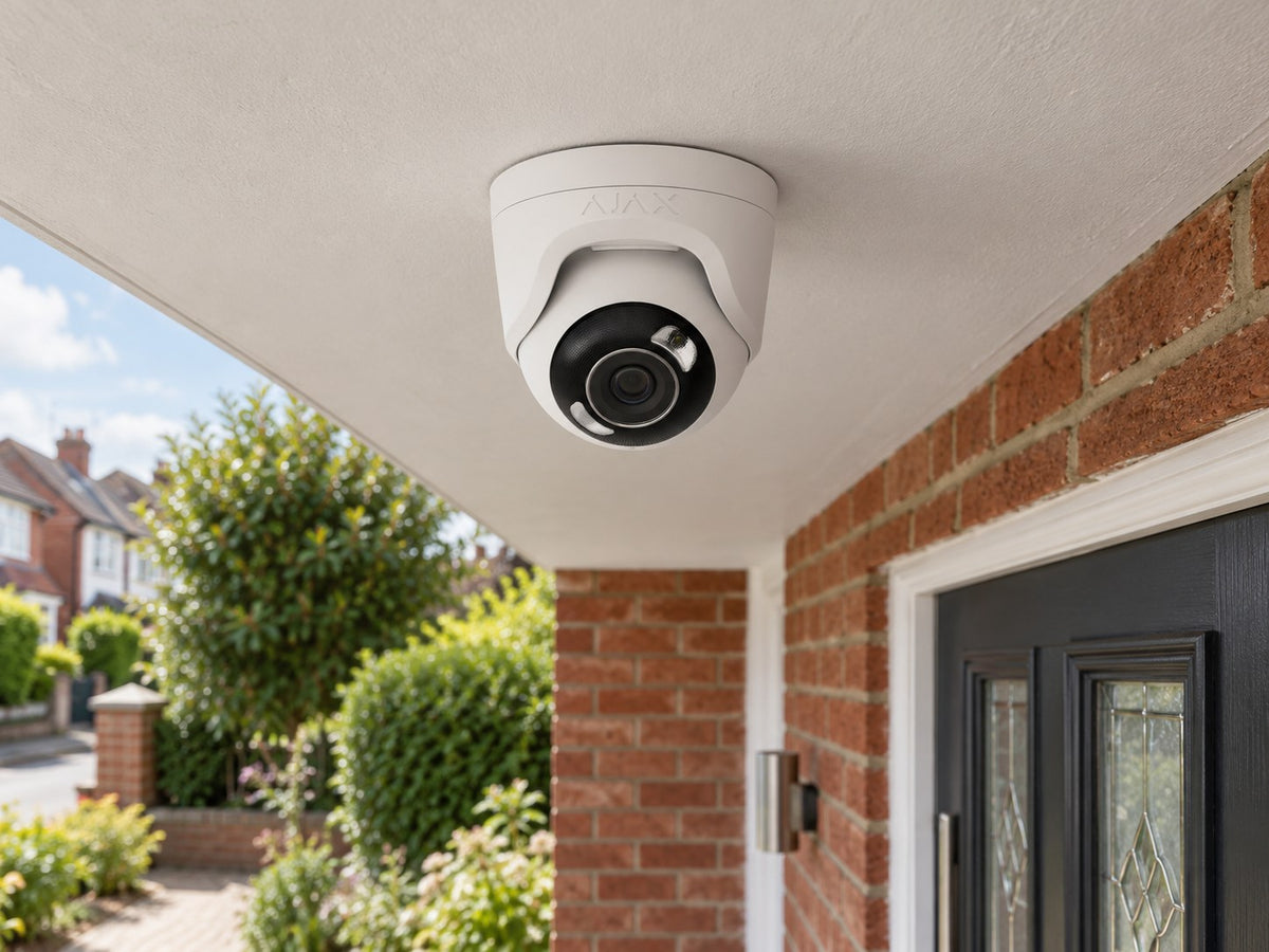Ajax TurretCam HL • 5MP 2.8mm • White installed in British red-brick home entrance porch, front door and small garden beyond.