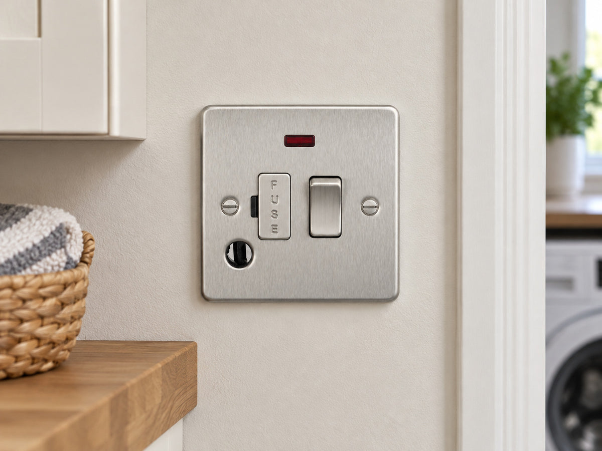 Knightsbridge FP6300FBC brushed chrome fused spur mounted on the wall in a dry UK utility-room wall near a cupboard, away from water and heat.