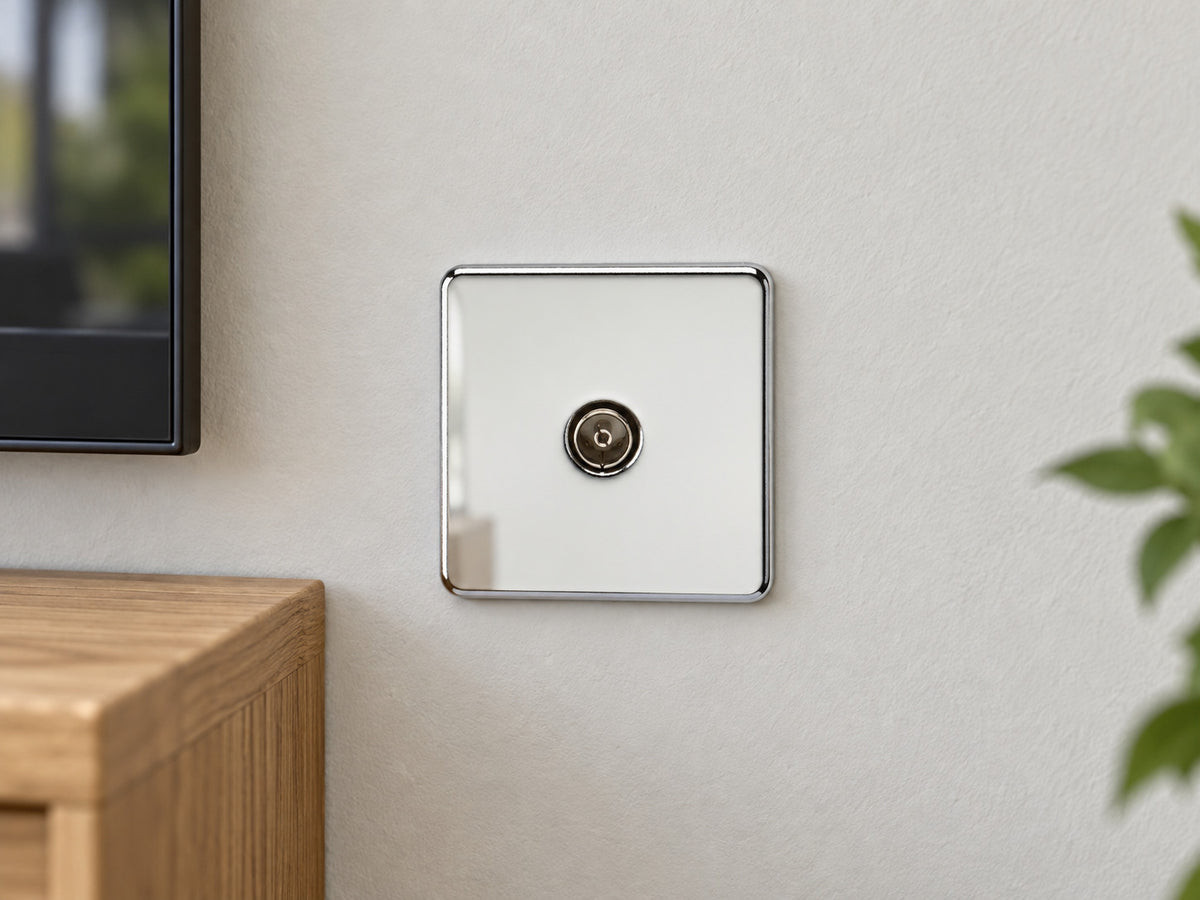 Knightsbridge SF0100PC polished chrome TV outlet fitted on a dry UK living-room wall beside an oak television cabinet.