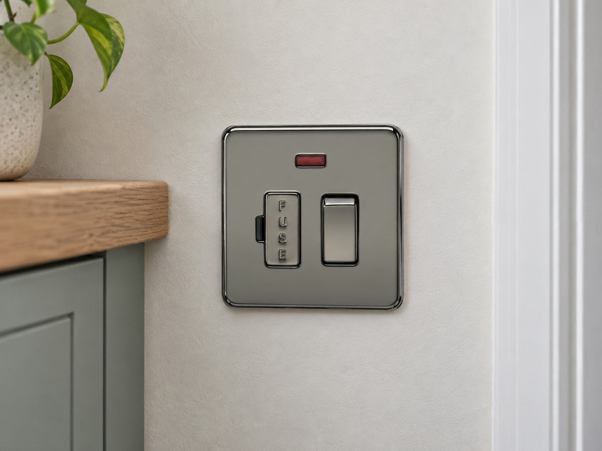Knightsbridge SF6300NBN black nickel fused spur fitted on a dry UK utility-room wall near a cupboard.