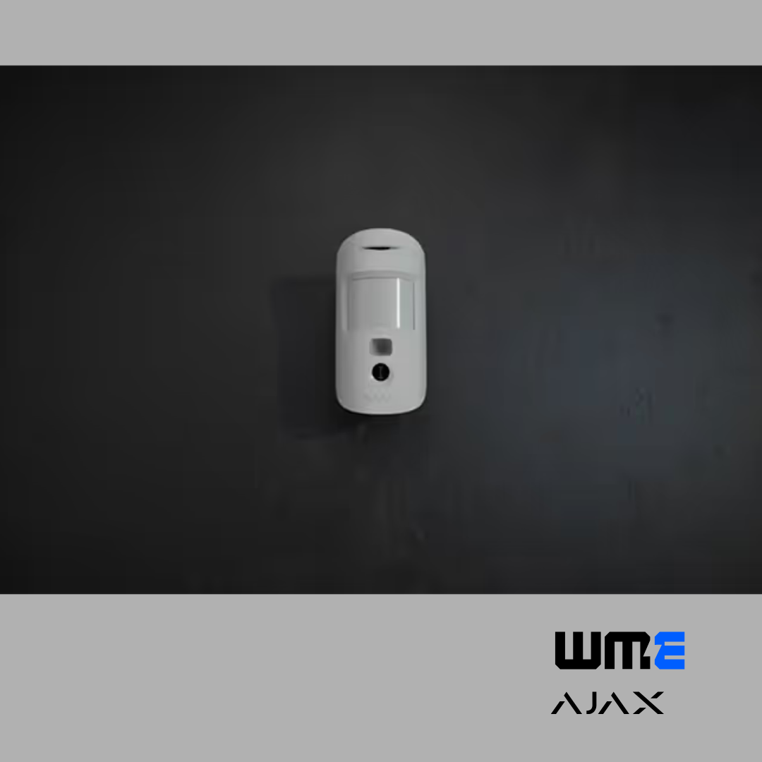 white Ajax motion detector on a dark wall