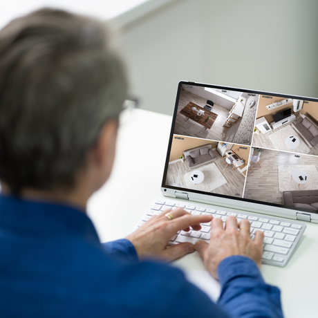 man looking at cctv on laptop 