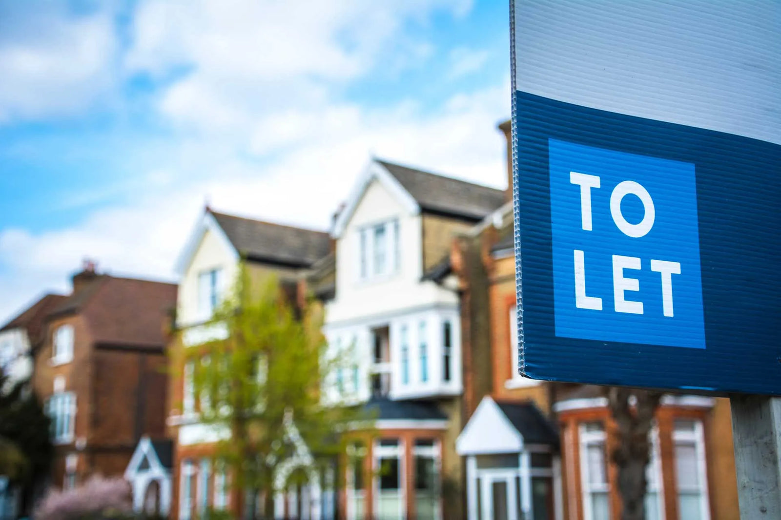 A to let sign outside a terrace of houses 