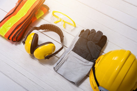 Standard construction safety equipment on white wooden background. safety first concepts