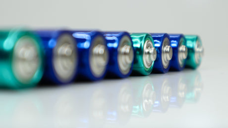 AA alkaline rechargeable batteries on white glossy background with reflection 