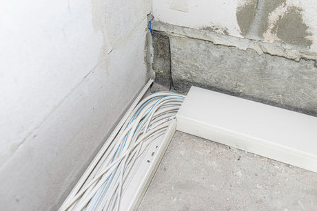 Layed installation of electric cables on the floor in a newly built house cables lying in plastic