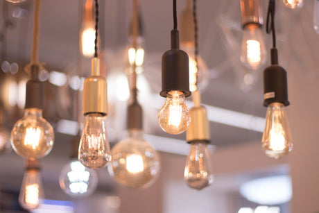 Close-up of illuminated light bulbs hanging from ceiling