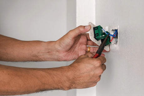 Close-up of man repairing switch on wall