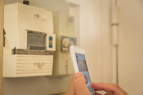 Cropped hands controlling electrical switch through mobile phone