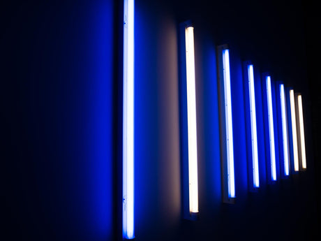 Illuminated fluorescent lights on wall in darkroom