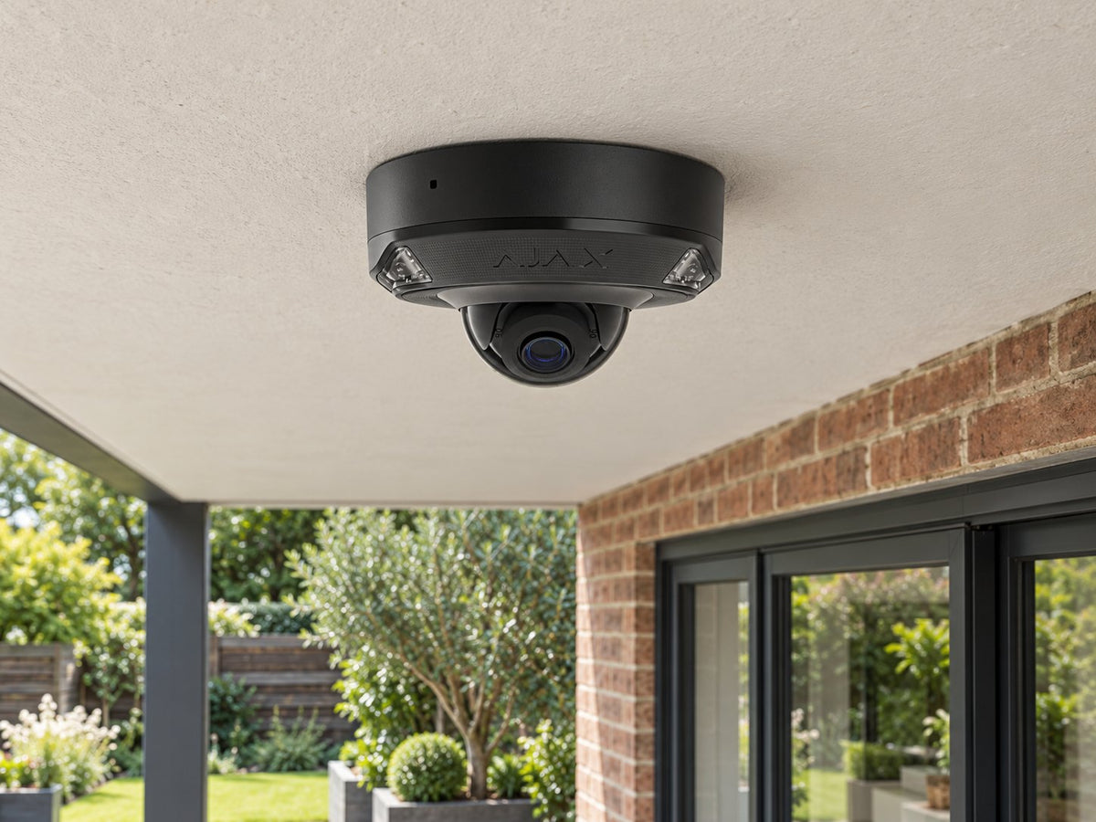 Ajax DomeCam Mini HL • 5MP 2.8mm • Black installed in British home covered rear patio, brick facade and planting below.