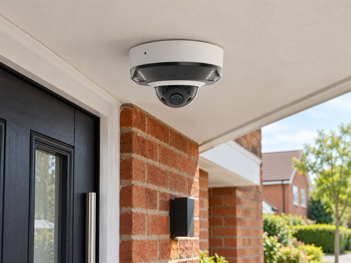 Ajax DomeCam Mini HL • 5MP 2.8mm • White installed in British red-brick home entrance porch, front door and small garden beyond.