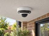 Ajax DomeCam Mini HL • 8MP 2.8mm • White installed in British home covered rear patio, brick facade and planting below.
