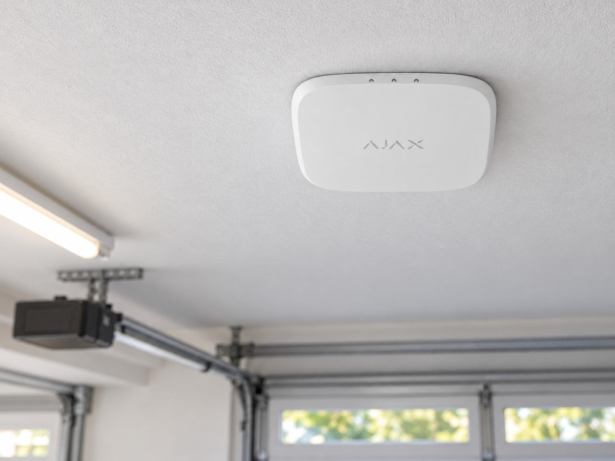White Ajax FireProtect 2 AC Heat/CO alarm mounted flat against a garage ceiling.