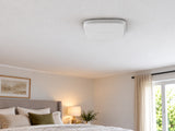 White Ajax FireProtect 2 SB Smoke/Heat alarm mounted flat against a bedroom ceiling.