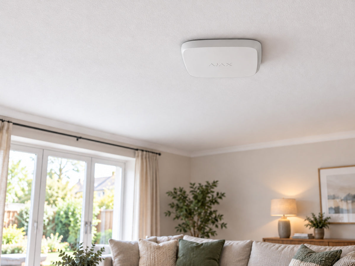 White Ajax FireProtect 2 SB Smoke/Heat alarm mounted flat against a living-room ceiling.
