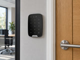 Ajax KeyPad black mounted beside an office entrance door.