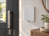 Ajax KeyPad Fibra White shown at an entrance hallway wall.