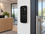 Ajax KeyPad TouchScreen • White installed in office reception beside glazed doorway.