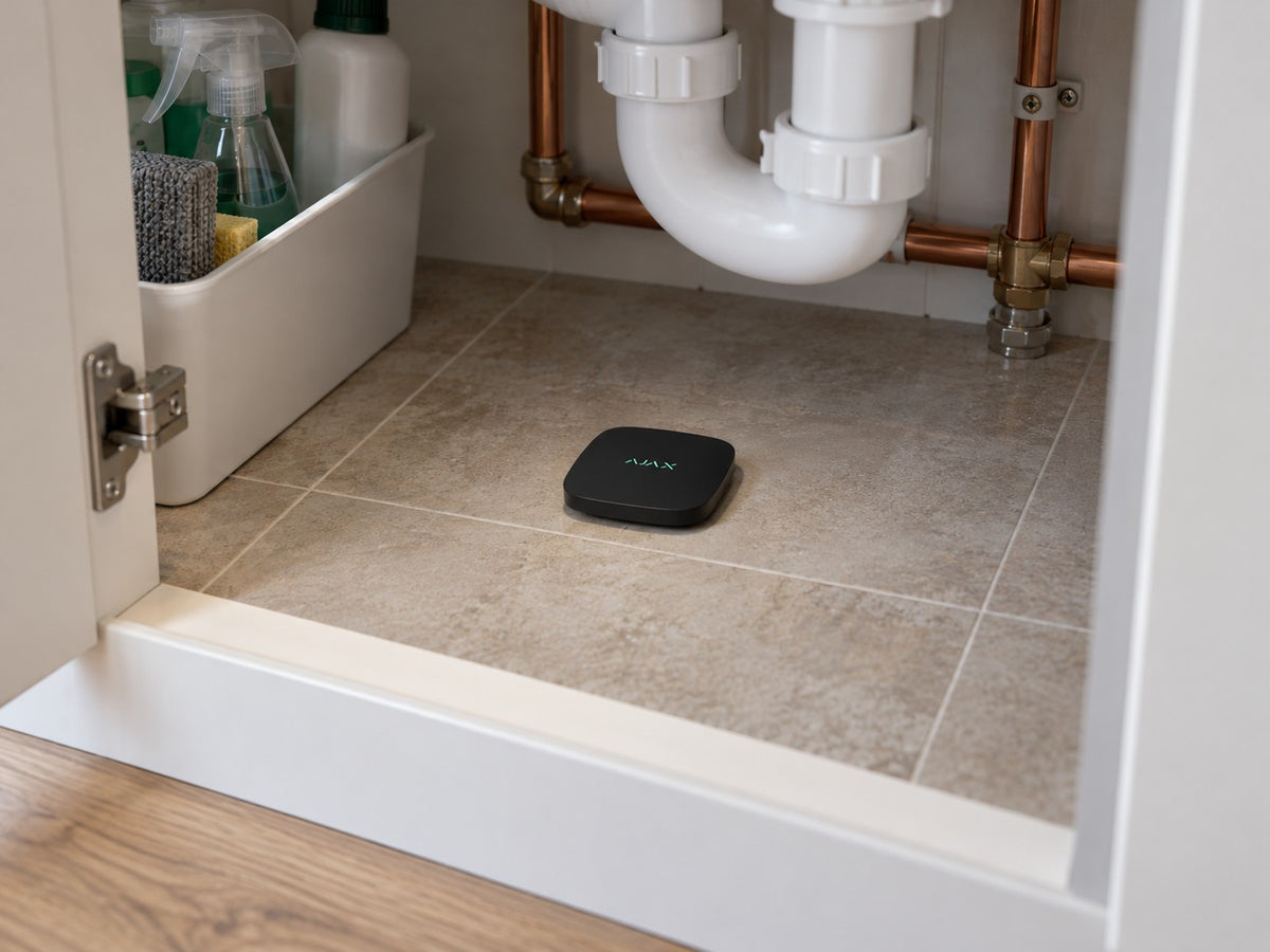 Ajax LeaksProtect 56209.08.BL1 installed in British kitchen under-sink cupboard.