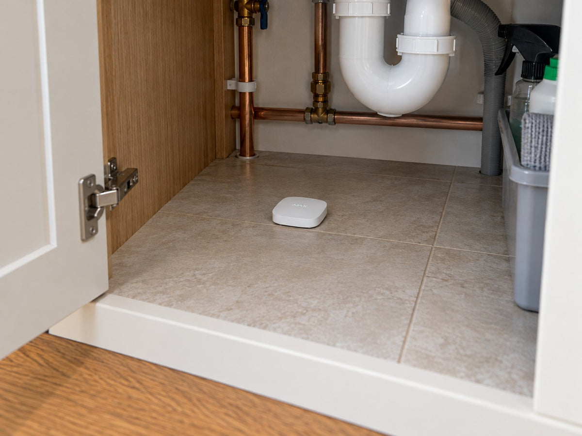 Ajax LeaksProtect 56210.08.WH1 installed in British kitchen under-sink cupboard.