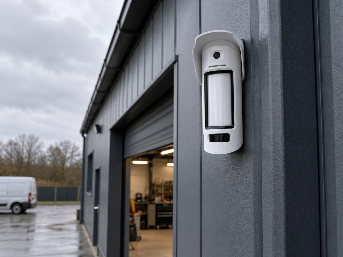 Ajax MotionCam Outdoor HighMount PhOD shown at a warehouse exterior wall.