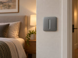 Ajax SoloButton Dimmer Grey shown at a bedroom wall.
