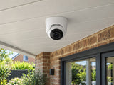 Ajax TurretCam • 8MP 4mm • White installed in British home covered rear patio, brick facade and planting below.