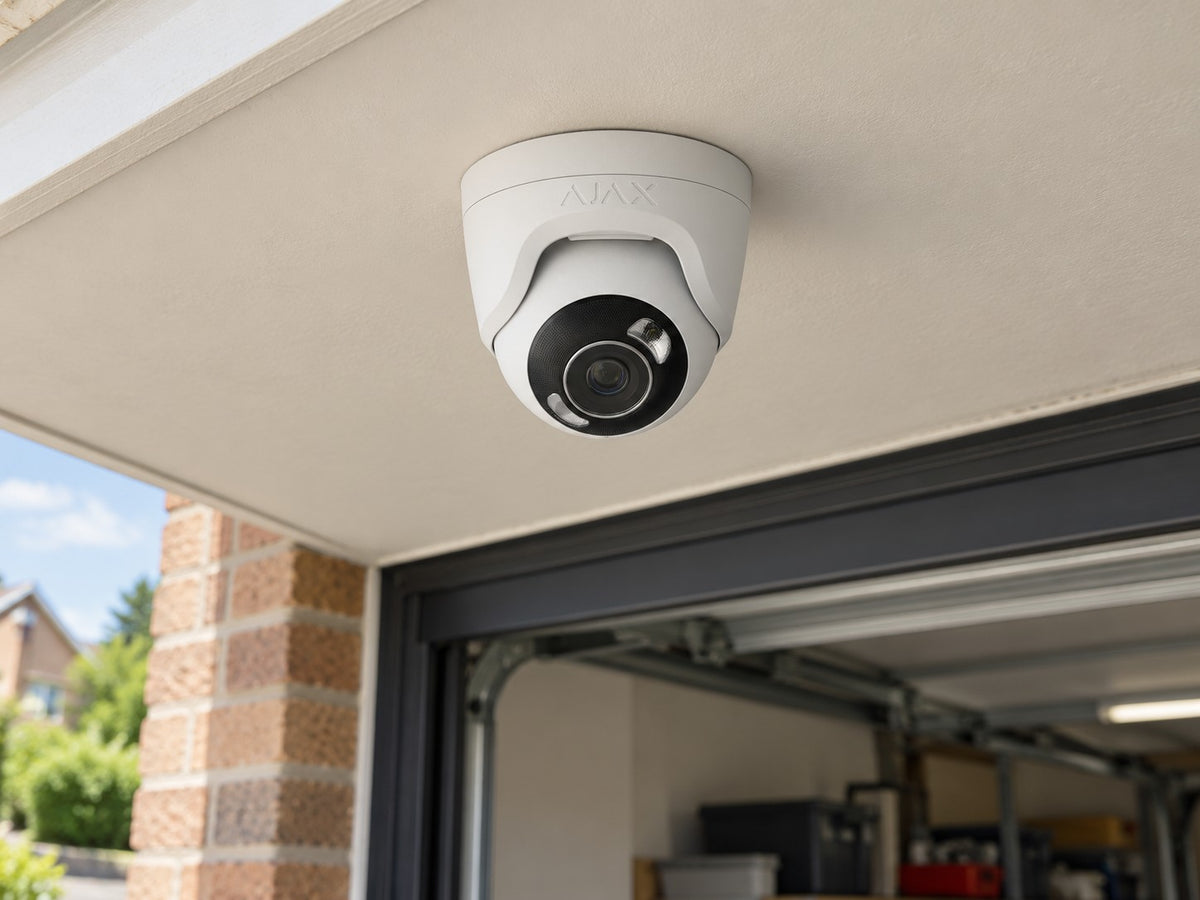 Ajax TurretCam HL • 8MP 4mm • White installed in British home garage entrance beneath a flat cream soffit.