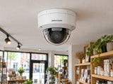Hikvision DS-2CD2166G2H-ISU (white) installed in British independent shop interior.