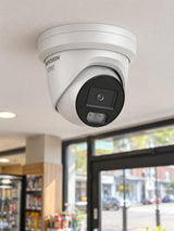 Hikvision DS-2CD2387G3-LI2UY at a shop entrance.