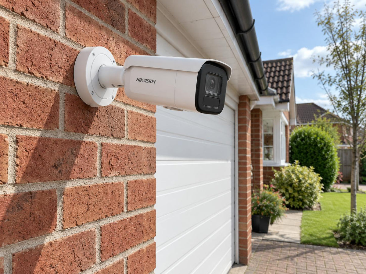 Hikvision DS-2CD2646G2H-IZS installed in British red-brick home driveway.