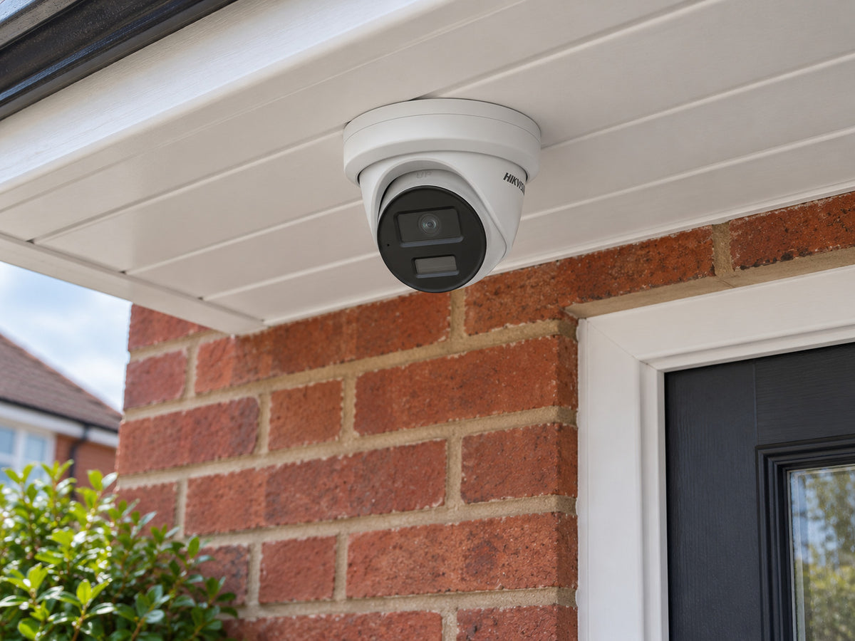 Hikvision DS-2CD3346G2-ISU white mounted beneath a house porch soffit.