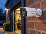 Hikvision DS-2CE10KF3T-LE (2.8 mm) shown at an evening shop entrance.