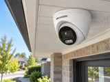 Hikvision DS-2CE72KF3T-LE (3.6 mm) shown at a brick house exterior.
