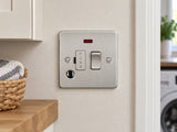 Knightsbridge FP6300FBC brushed chrome fused spur mounted on the wall in a dry UK utility-room wall near a cupboard, away from water and heat.