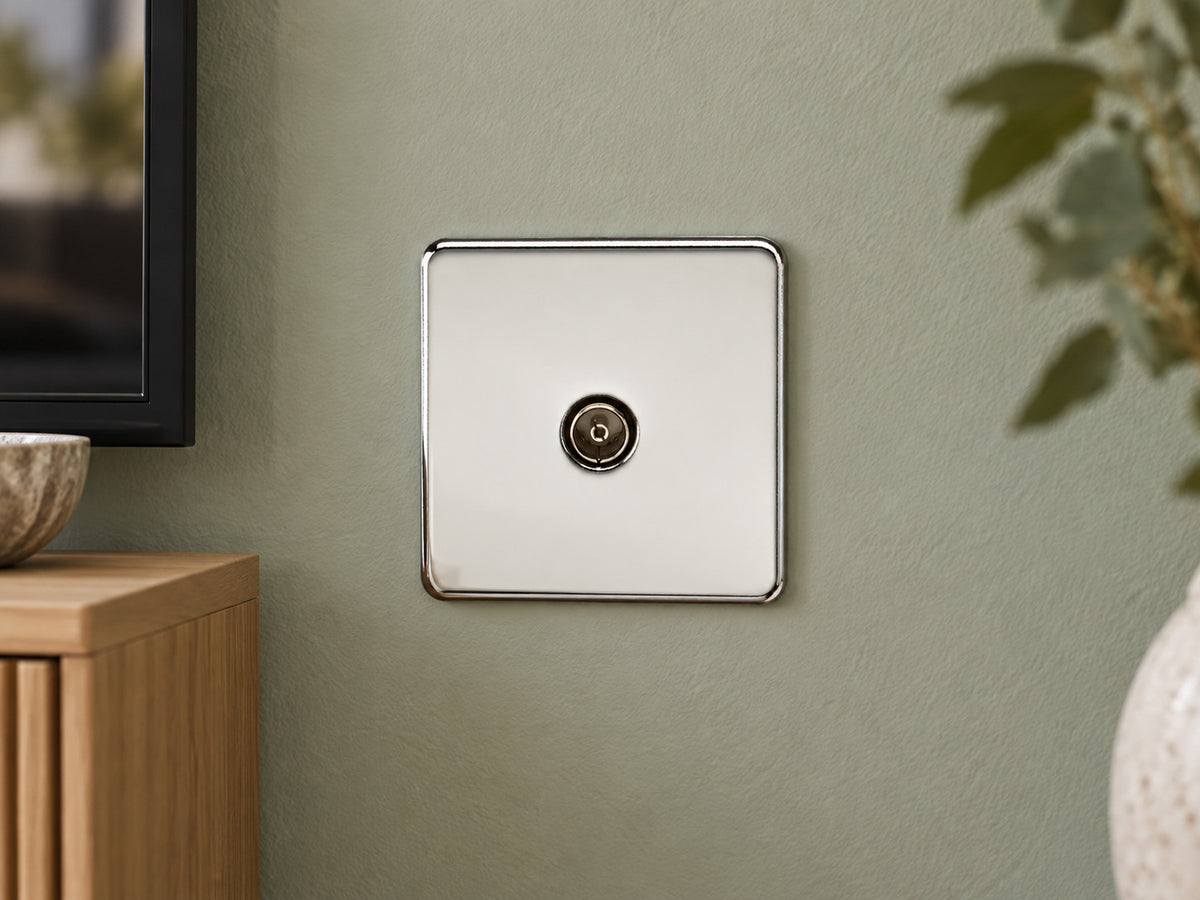 Knightsbridge SF0100PC polished chrome TV outlet fitted on a dry UK sitting-room wall near a media console with soft sage paint.