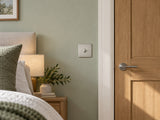 Knightsbridge SF1TOGBC brushed chrome toggle switch fitted flush in UK bedroom beside a doorway.