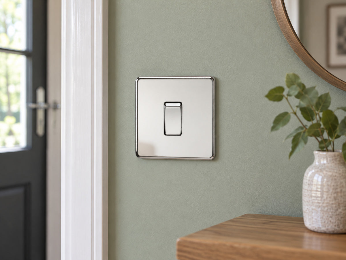 Knightsbridge SF2000PC polished chrome light switch installed on a UK living-room entrance wall with muted sage paint.