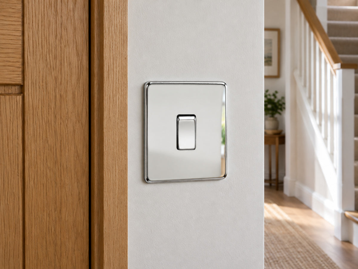 Knightsbridge SF2000PC polished chrome light switch installed on a UK hallway wall beside an oak door frame.