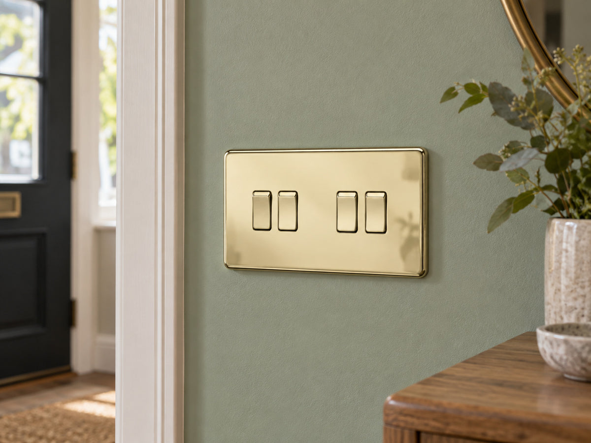 Knightsbridge SF4100PB polished brass light switch installed on a UK living-room entrance wall with muted sage paint.