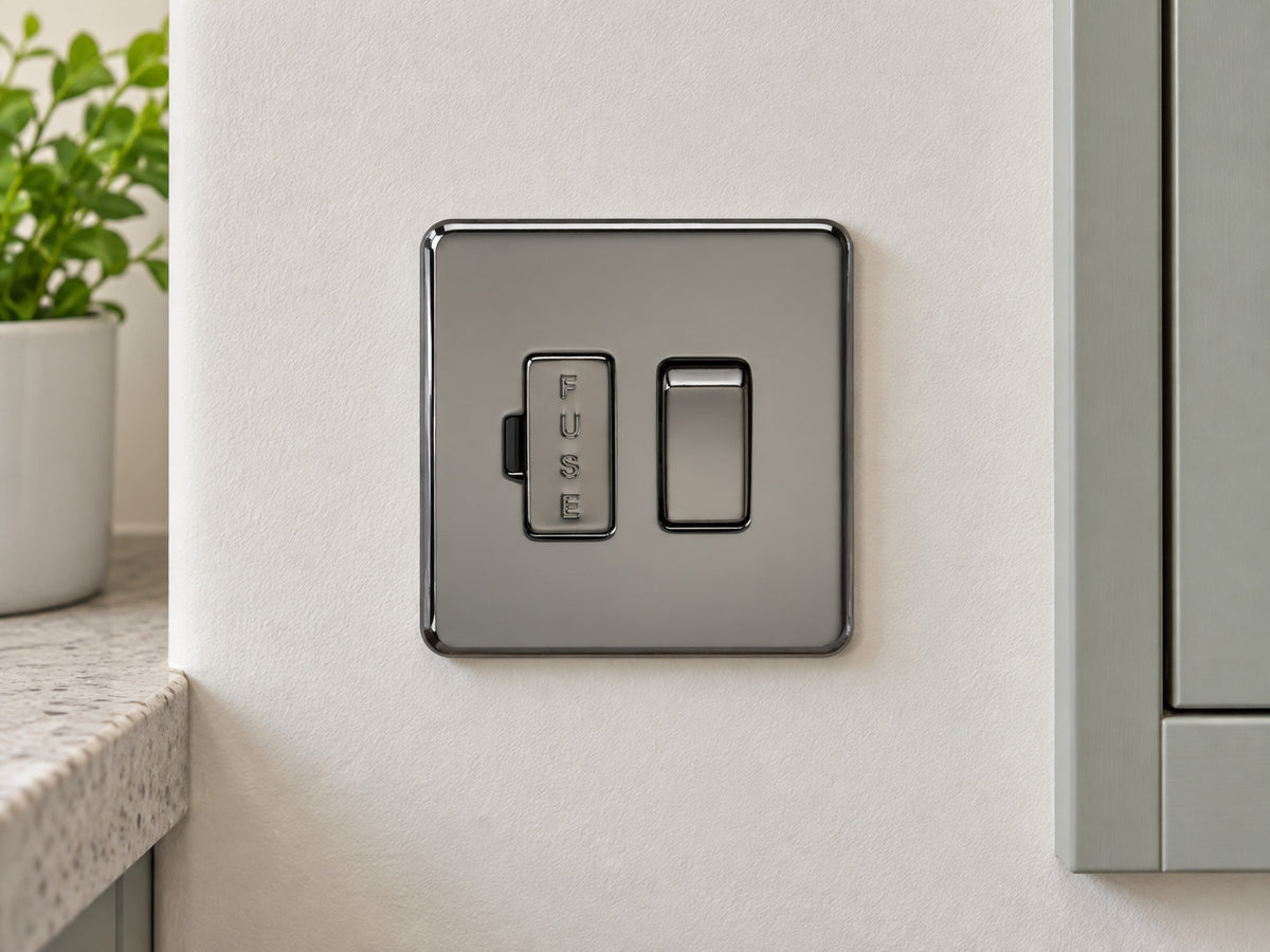 Knightsbridge SF6300BN black nickel fused spur fitted on a dry UK utility-room wall near a cupboard.